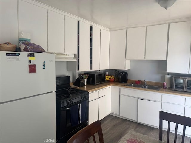 13538 Lukay St, Whittier, CA 90605 - kitchen with freestanding refrigerator, black range with gas stovetop, stainless steel microwave, white cabinets, and dark wood-type flooring