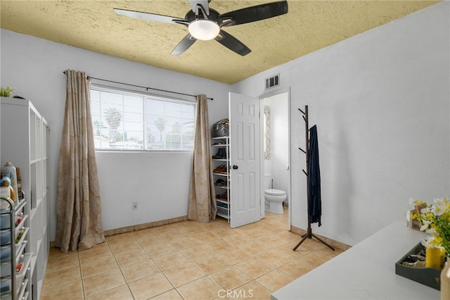 510 Archibald Ct, Colton, CA 92324 - bedroom with light tile patterned flooring, a textured ceiling, ceiling fan, baseboards, and ensuite bath