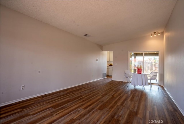 25717 Leah Ln, Menifee, CA 92586 - unfurnished living room with dark wood-type flooring, vaulted ceiling, baseboards, and a textured ceiling