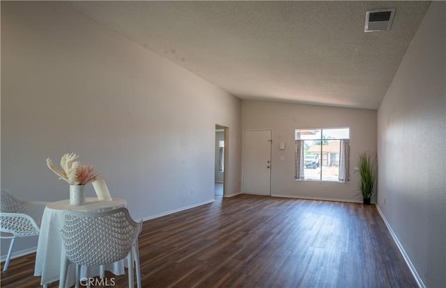 25717 Leah Ln, Menifee, CA 92586 - unfurnished living room with vaulted ceiling, dark wood-type flooring, a textured ceiling, and baseboards