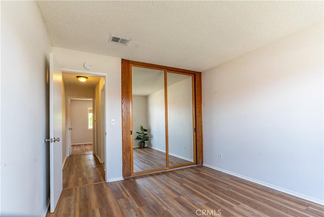 25717 Leah Ln, Menifee, CA 92586 - unfurnished bedroom featuring wood finished floors, a closet, a textured ceiling, and baseboards