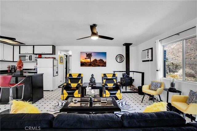 49490 Big Morongo Canyon Rd, Morongo Valley, CA 92256 - living area featuring a wood stove, a ceiling fan, light carpet, and an AC wall unit