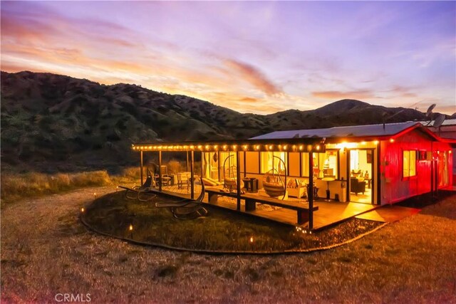 49490 Big Morongo Canyon Rd, Morongo Valley, CA 92256 - back of property at dusk featuring a mountain view and a patio area