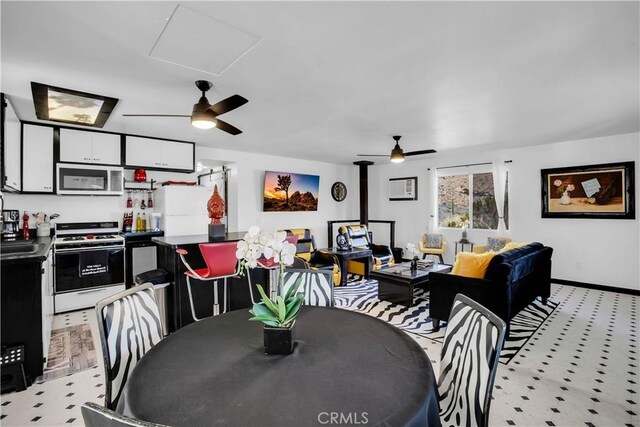 49490 Big Morongo Canyon Rd, Morongo Valley, CA 92256 - dining space with a ceiling fan, a wood stove, and light floors
