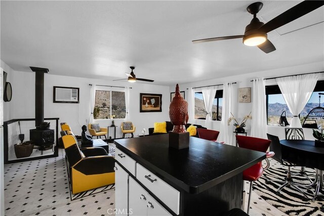 49490 Big Morongo Canyon Rd, Morongo Valley, CA 92256 - kitchen with a ceiling fan, a wood stove, white cabinets, dark countertops, and open floor plan