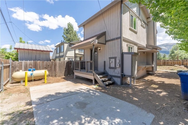 2100 1st Ln, Big Bear City, CA 92314 - back of property featuring a fenced backyard, a mountain view, and a patio