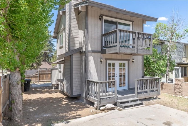 2100 1st Ln, Big Bear City, CA 92314 - back of property with a balcony, french doors, a fenced backyard, a chimney, and a wooden deck
