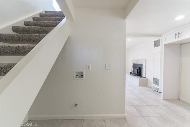 2100 1st Ln, Big Bear City, CA 92314 - staircase with a heating unit, a wood stove, tile patterned flooring, and baseboards