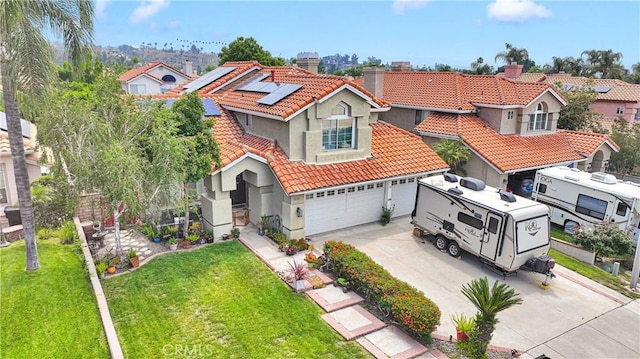 7223 Yarnell Rd, Highland, CA 92346 - mediterranean / spanish house featuring driveway, a tile roof, stucco siding, a chimney, and solar panels
