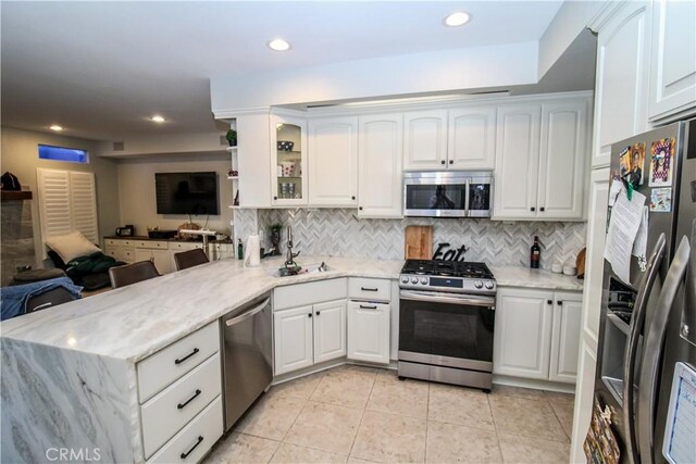 7223 Yarnell Rd, Highland, CA 92346 - kitchen with appliances with stainless steel finishes, a sink, a peninsula, open floor plan, and light tile patterned flooring