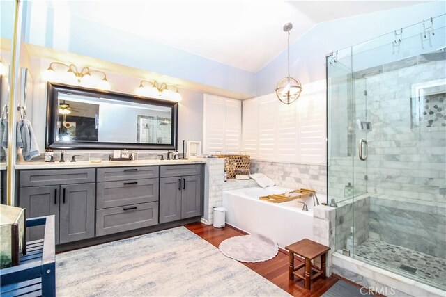 7223 Yarnell Rd, Highland, CA 92346 - bathroom with a bath, double vanity, a shower stall, lofted ceiling, and wood finished floors