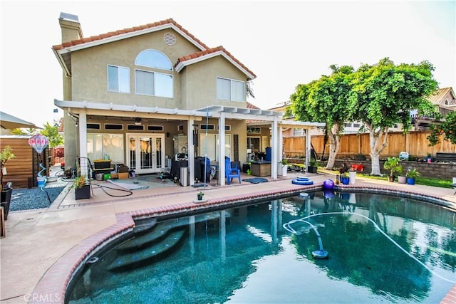 7223 Yarnell Rd, Highland, CA 92346 - rear view of house featuring french doors, a chimney, a fenced backyard, and stucco siding