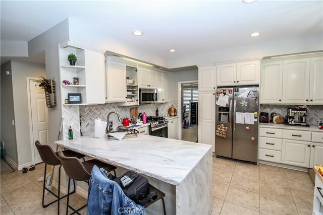 7223 Yarnell Rd, Highland, CA 92346 - kitchen featuring stainless steel appliances, open shelves, a breakfast bar area, a peninsula, and decorative backsplash