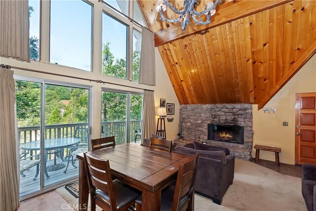 1192 Evergreen Ln, Lake Arrowhead, CA 92352 - dining area with high vaulted ceiling, a chandelier, healthy amount of natural light, and a stone fireplace
