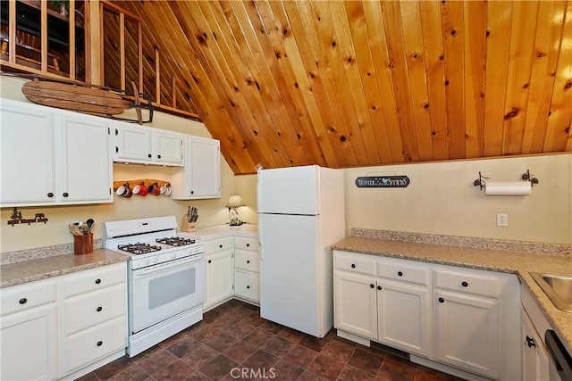 1192 Evergreen Ln, Lake Arrowhead, CA 92352 - kitchen with white appliances, white cabinets, light countertops, stone finish flooring, and lofted ceiling