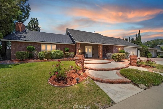 3021 E Hartford Rd, Orange, CA 92869 - view of front of house with an attached garage, a front yard, a chimney, concrete driveway, and brick siding