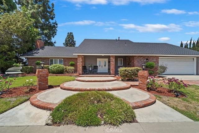 3021 E Hartford Rd, Orange, CA 92869 - view of front facade with an attached garage, a chimney, brick siding, and concrete driveway
