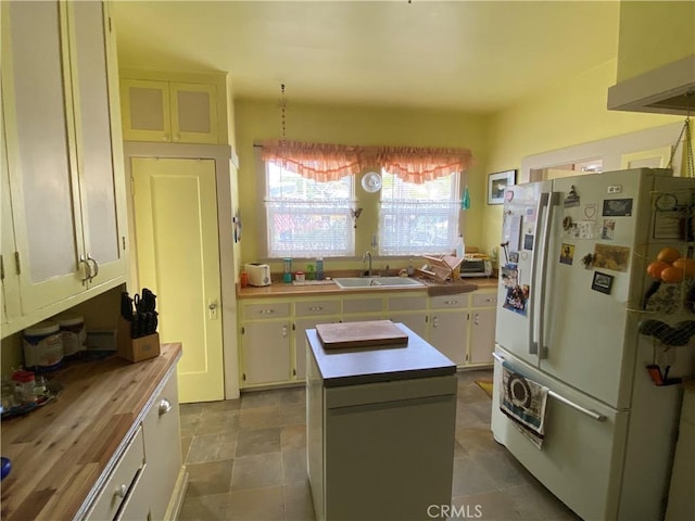 201 Old Creek Rd, Cayucos, CA 93430 - kitchen with freestanding refrigerator, a sink, white cabinetry, and a kitchen island