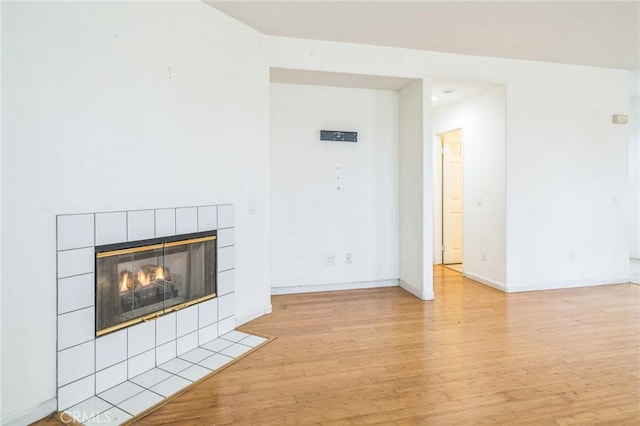 1065 Vaquero Cir, Oxnard, CA 93030 - unfurnished living room with light wood finished floors, a tile fireplace, and baseboards