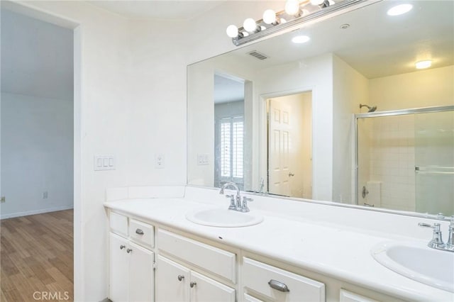 1065 Vaquero Cir, Oxnard, CA 93030 - bathroom with double vanity, a tile shower, wood finished floors, baseboards, and recessed lighting