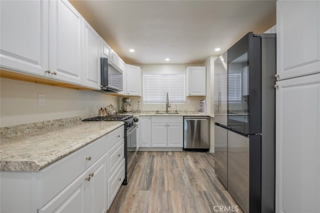 2052 Chenault Pl, Simi Valley, CA 93065 - kitchen with stainless steel appliances, a sink, light wood-style floors, white cabinets, and recessed lighting