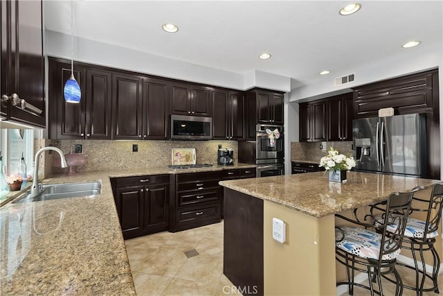 25079 Loring Rd, Wildomar, CA 92595 - kitchen with stainless steel appliances, a sink, a breakfast bar area, light stone countertops, and a center island