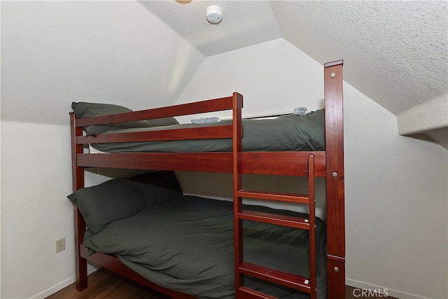 33294 Wild Rose Dr, Green Valley Lake, CA 92341 - bedroom with vaulted ceiling, baseboards, wood finished floors, and a textured ceiling