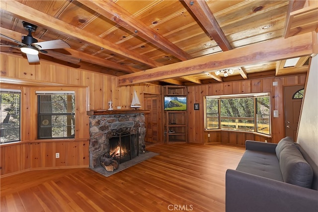 33294 Wild Rose Dr, Green Valley Lake, CA 92341 - living area with wood walls, wood-type flooring, a fireplace, healthy amount of natural light, and wood ceiling with exposed beams