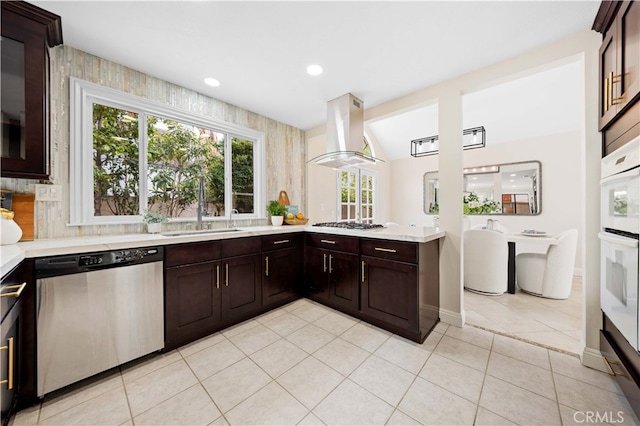 20 Chenile, Irvine, CA 92614 - kitchen featuring dishwasher, island exhaust hood, light countertops, dark brown cabinetry, and light tile patterned floors