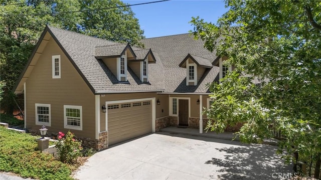 765 Del Norte Ln, Lake Arrowhead, CA 92352 - view of front of property with concrete driveway, stone siding, a garage, and roof with shingles