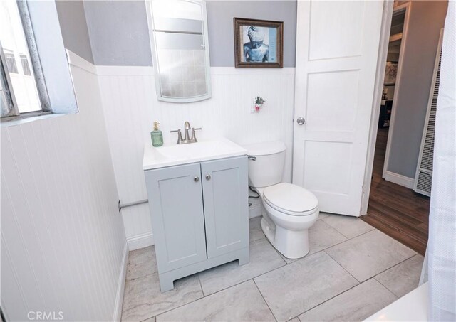 14121 Calais St, Baldwin Park, CA 91706 - full bath featuring a wainscoted wall, vanity, toilet, a heating unit, and tile patterned flooring