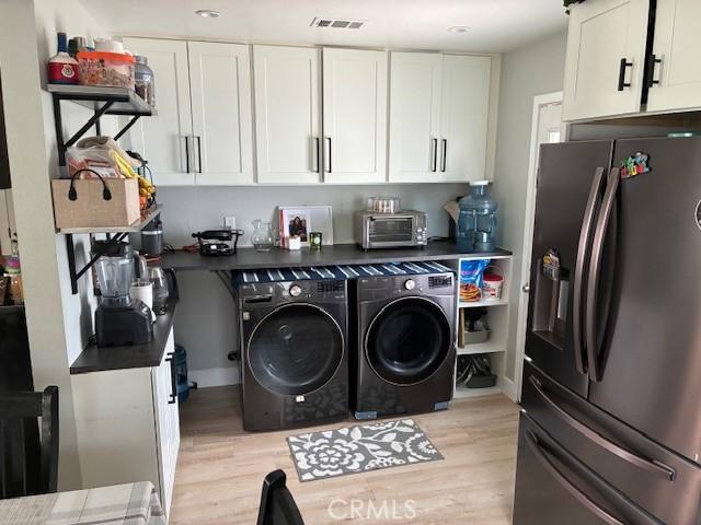3535 N Mountain View Ave, San Bernardino, CA 92405 - laundry area with light wood-style floors and washing machine and clothes dryer