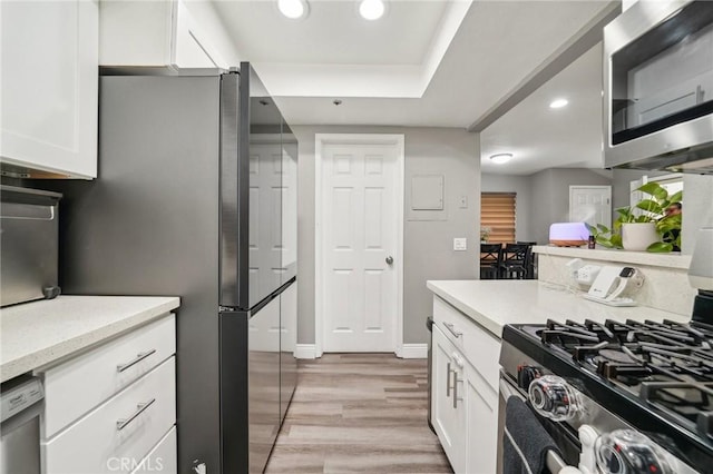 8167 Vineyard Ave Unit 109, Rancho Cucamonga, CA 91730 - kitchen with stainless steel appliances, white cabinetry, light wood-type flooring, recessed lighting, and light stone counters