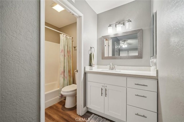 8167 Vineyard Ave Unit 109, Rancho Cucamonga, CA 91730 - bathroom with wood finished floors, toilet, vanity, a textured wall, and shower / tub combo with curtain