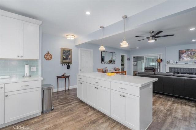 1501 W Baker Ave, Fullerton, CA 92833 - kitchen featuring wood finished floors, decorative backsplash, light countertops, a ceiling fan, and pendant lighting