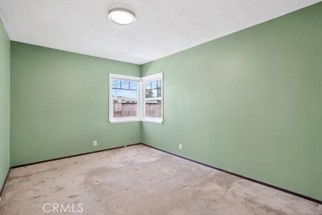 1501 W Baker Ave, Fullerton, CA 92833 - empty room with carpet floors and a textured ceiling