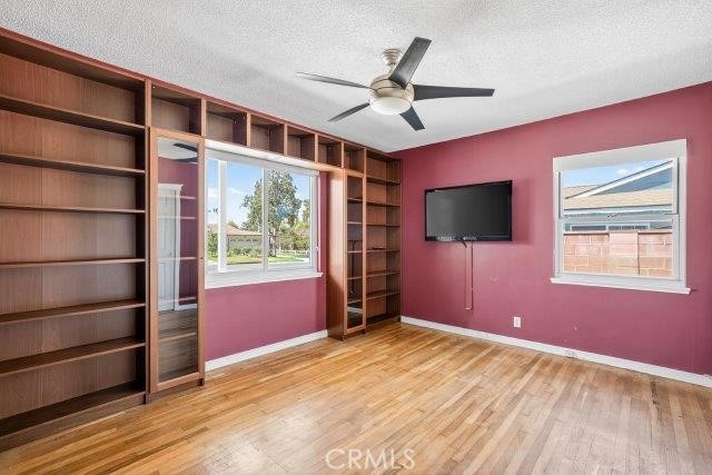 1501 W Baker Ave, Fullerton, CA 92833 - empty room featuring a textured ceiling, wood finished floors, a ceiling fan, and built in features
