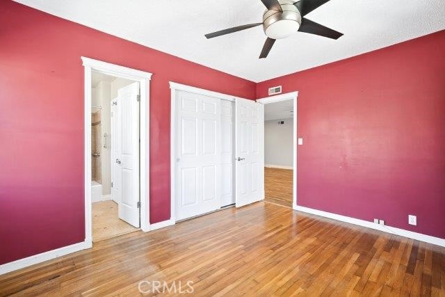 1501 W Baker Ave, Fullerton, CA 92833 - unfurnished bedroom with wood finished floors, a closet, connected bathroom, and ceiling fan
