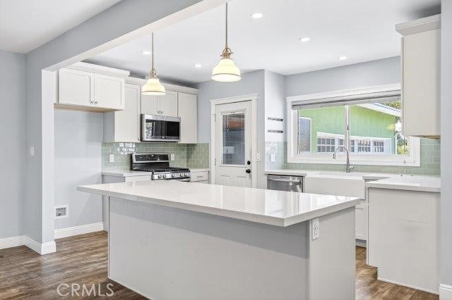 1501 W Baker Ave, Fullerton, CA 92833 - kitchen featuring stainless steel appliances, white cabinets, decorative backsplash, light countertops, and dark wood finished floors