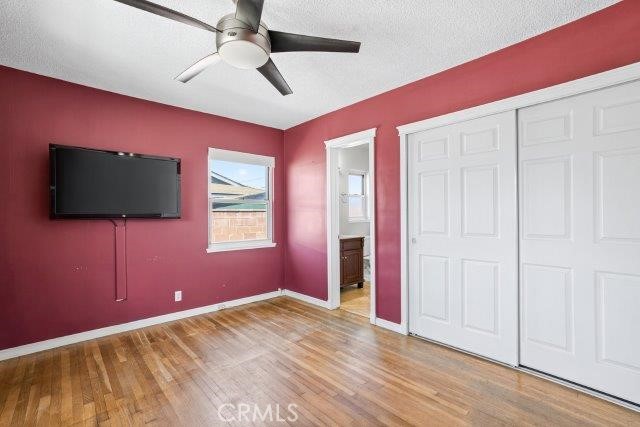 1501 W Baker Ave, Fullerton, CA 92833 - unfurnished bedroom featuring wood finished floors, a closet, ensuite bath, ceiling fan, and a textured ceiling