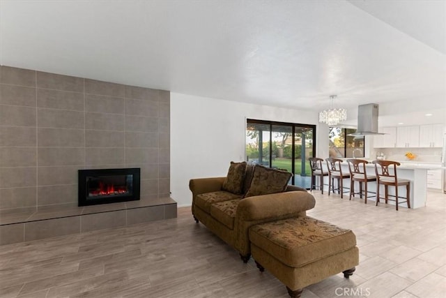 42722 20th St W, Lancaster, CA 93534 - living room with a chandelier, a tiled fireplace, and light wood-style floors