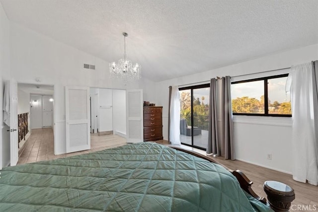 42722 20th St W, Lancaster, CA 93534 - bedroom with access to outside, a textured ceiling, a chandelier, lofted ceiling, and wood finished floors