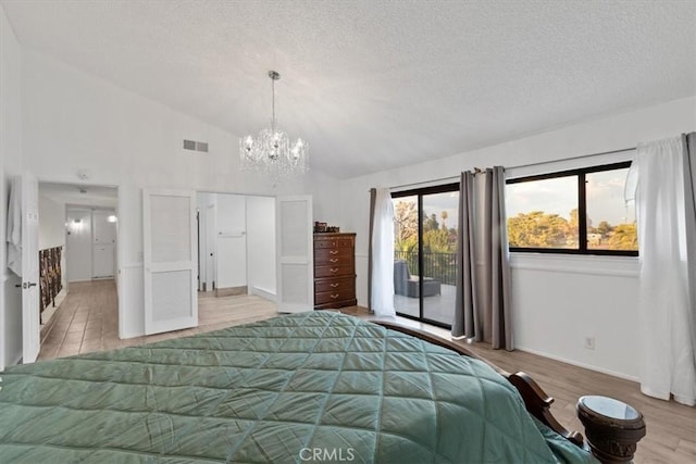 42722 20th St W, Lancaster, CA 93534 - bedroom with access to exterior, a textured ceiling, a chandelier, vaulted ceiling, and wood finished floors