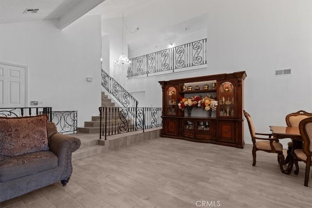 42722 20th St W, Lancaster, CA 93534 - living room featuring high vaulted ceiling, a chandelier, stairs, and wood finished floors