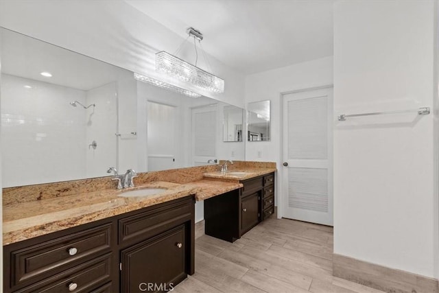 42722 20th St W, Lancaster, CA 93534 - bathroom with double vanity, a shower, and wood finished floors