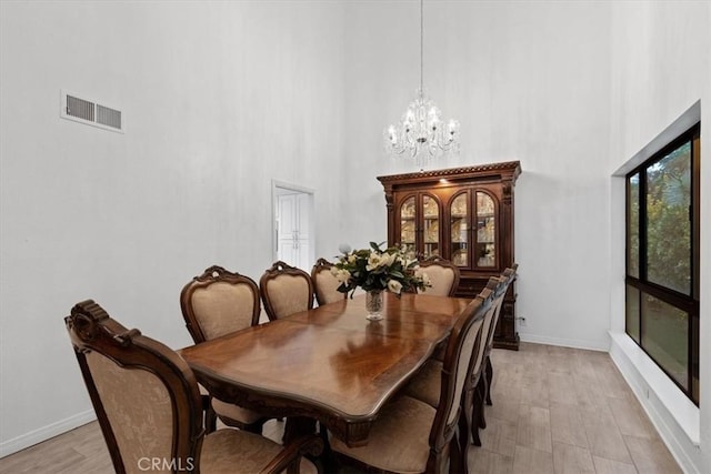 42722 20th St W, Lancaster, CA 93534 - dining area featuring a high ceiling, a chandelier, baseboards, and light wood-style flooring