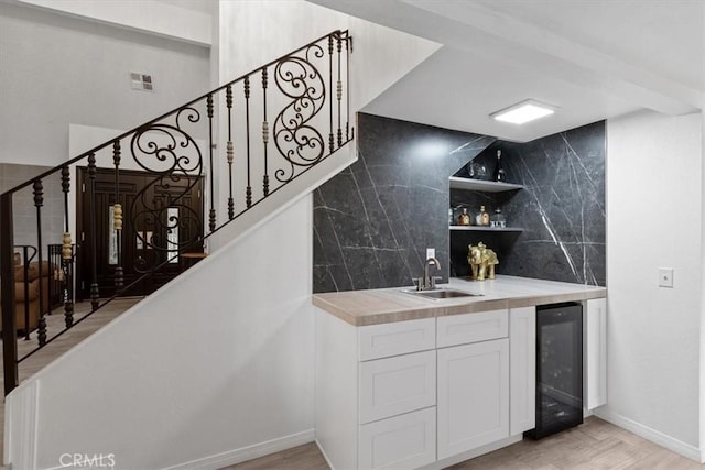 42722 20th St W, Lancaster, CA 93534 - indoor wet bar featuring beverage cooler, stairs, backsplash, and light wood finished floors