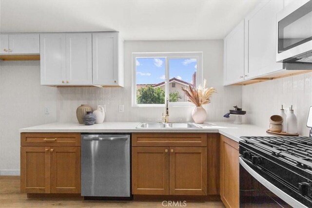 246 Aldama Ave, Pomona, CA 91767 - kitchen featuring stainless steel appliances, light countertops, white cabinets, and brown cabinets