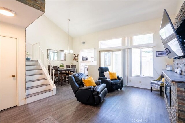 1643 Golden Tree Ct Unit C, Corona, CA 92879 - living room with wood finished floors, a chandelier, a fireplace, stairs, and a high ceiling