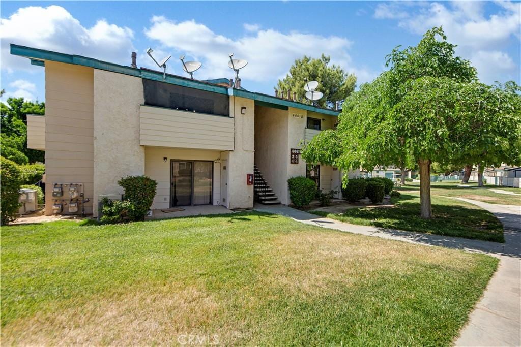 44418 15th St E Unit 3, Lancaster, CA 93535 - view of front of property with stucco siding, a front yard, and stairway